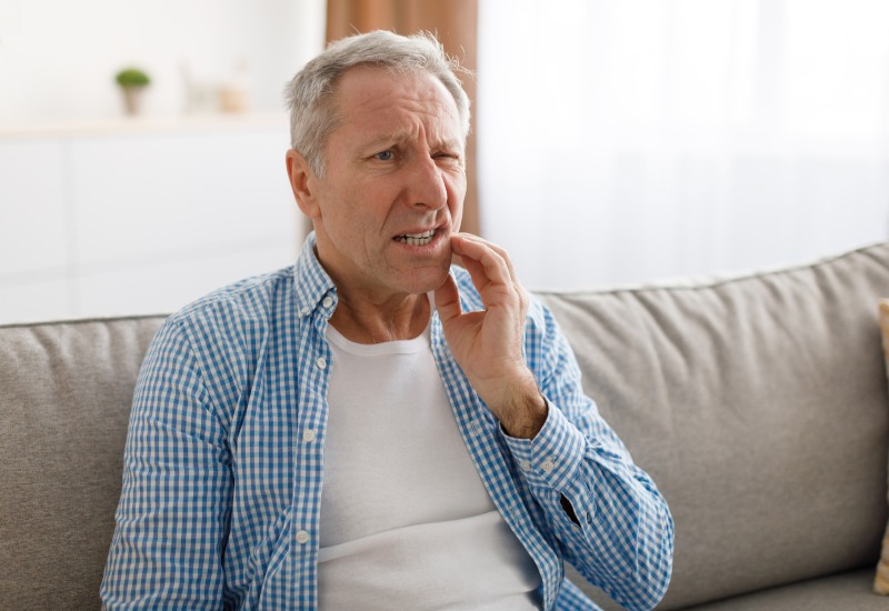 An elderly man suffering from Tooth Pain before receiving treatment from OKC Dentistry in Oklahoma.
