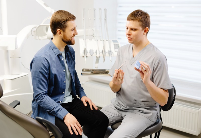 A dentist explaining patient about his oral cancer screening session in Greater Oklahoma City